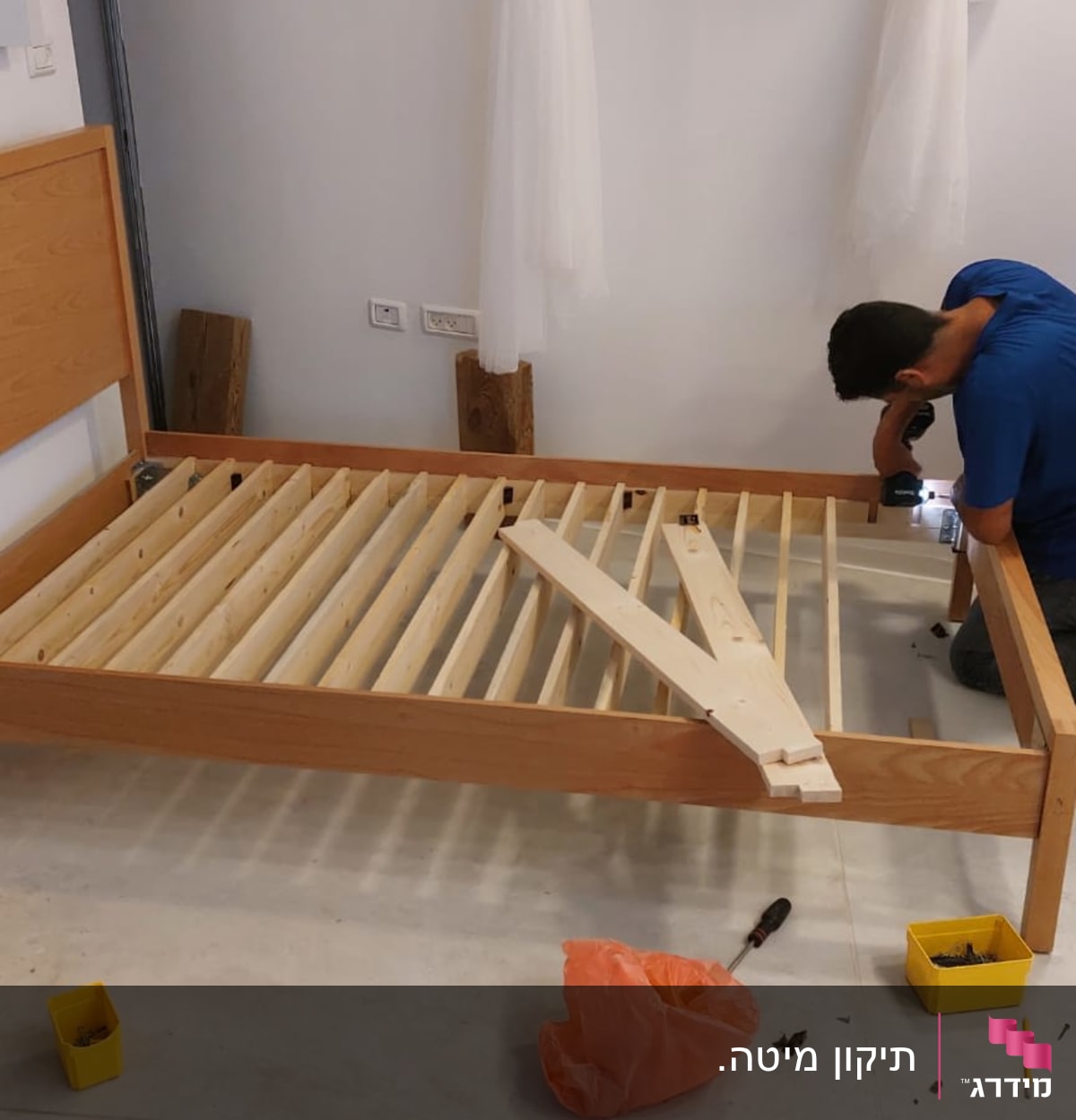 נגר מרכיב מיטה מעץ עם מברגה חשמלית